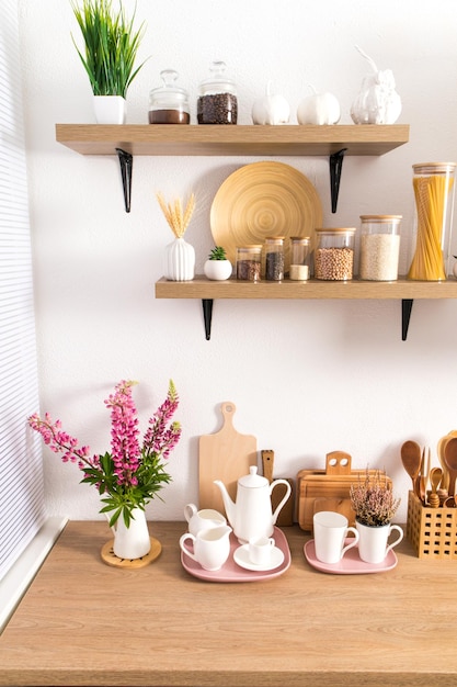 Part of the interior of the modern kitchen open shelves with various jars and countertop with kitchen utensils ecologically clean kitchen