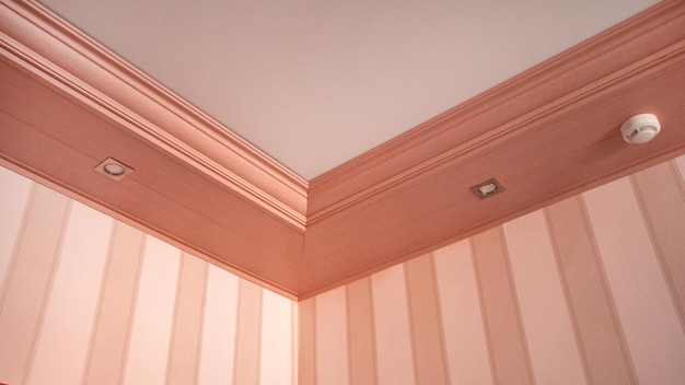 Part of the living room corner of the wall from the ceiling mounted LED lights in a wooden console on the ceiling pink tinting