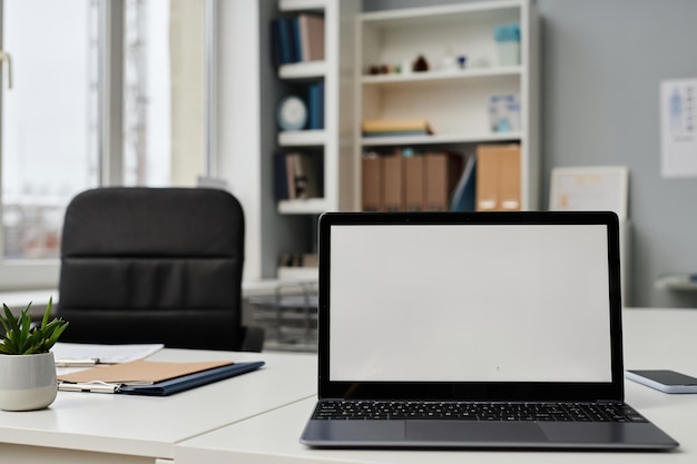 Part of office interior with laptop on desk