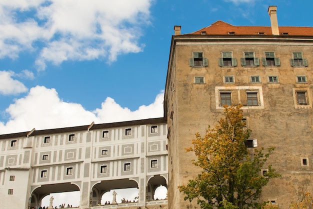 Part of old beautiful castle with sculptures and people