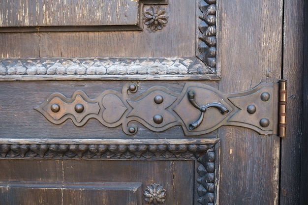 Part of an old wooden door with a stained glass pattern.