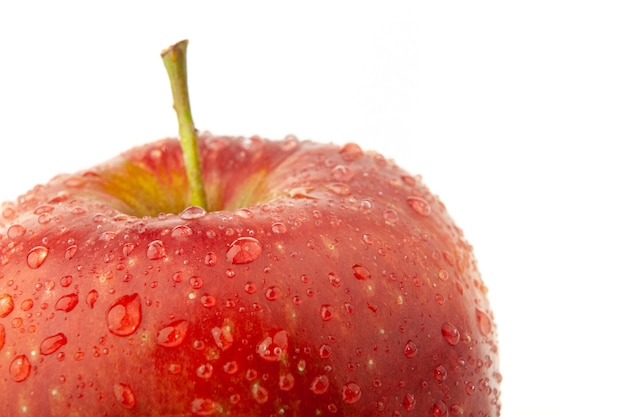 Part of a red apple with water drops on white