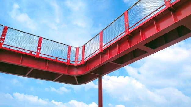 Part of red metal skywalk against white clouds on blue sky background in low angle view