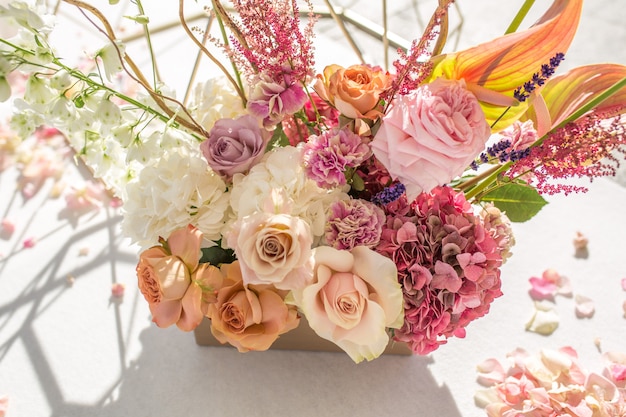 Part of the wedding arch decorated with fresh flowers is set on the sandy bank of the river. Wedding florist arranges workflow