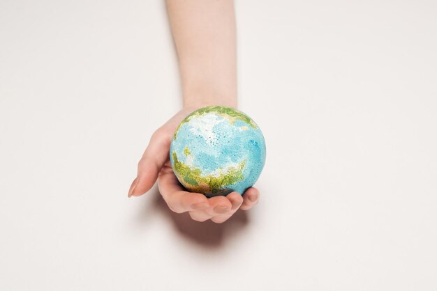 partial view of female hand with earth model on white background global warming concept