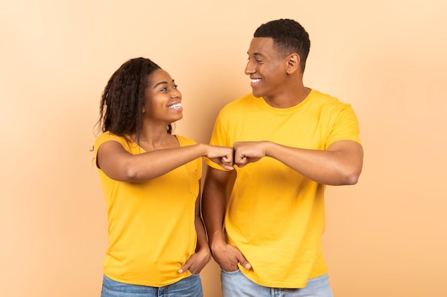 Partnership and collaboration work as team Smiling black man and woman making fist bumps looking at each other