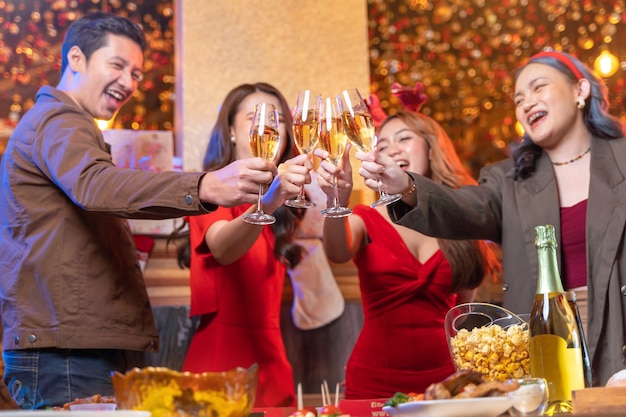 Party of asian Friends Enjoying Christmas Drinks and celebrating close up glasses of clinking