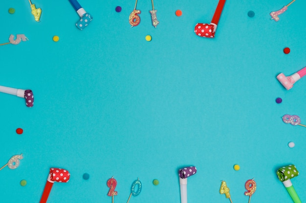 Party blowers or whistles in blue background with high top view.