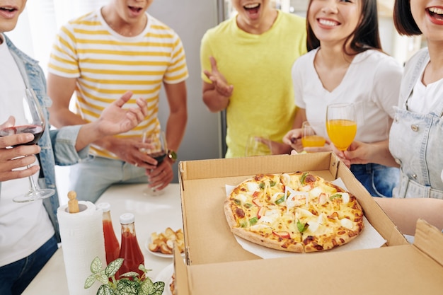 Party host opening box of pizza