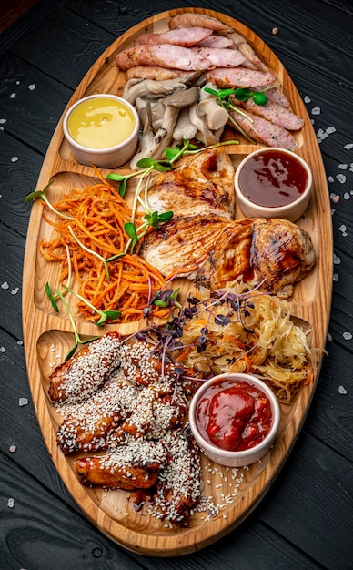 Party set Big set of appetizers wings meat grilled sausages with vegetables