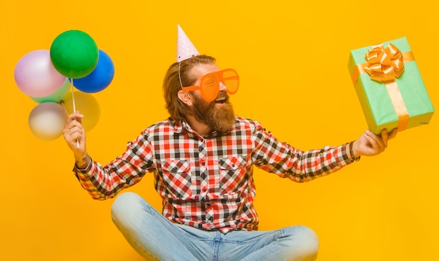 Photo party time. happy bearded man with present and balloons. holidays and celebration.