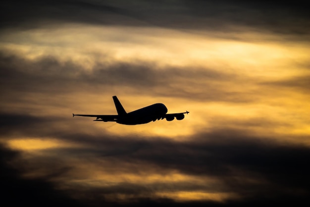 Passanger plane flying Airliner in the sky Aircraft take off in sunset