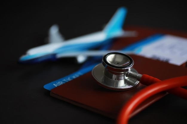 Passenger air insurance concept Airplane passport boarding pass and stethoscope