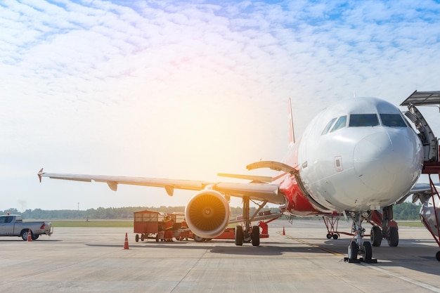 Passenger airplane stand by for loading luggage and move to conveyor at the international airport concpept flight transport by air