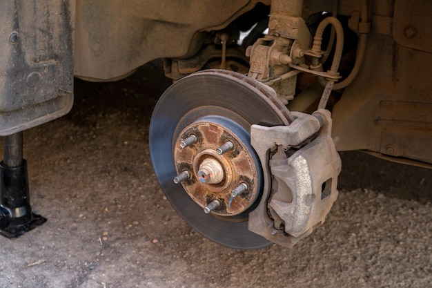 Passenger car with the front wheel removed Replacement of brake pads