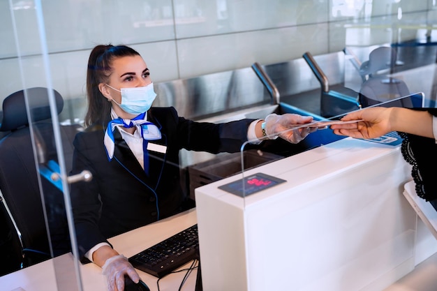 Passenger giving his documents for checkin to airport manager by counter