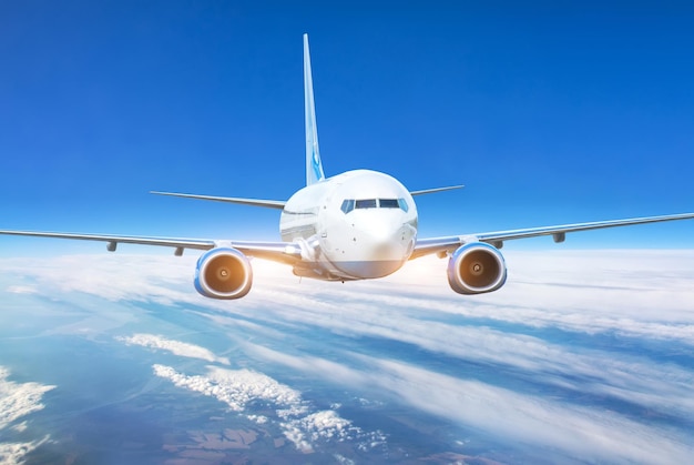 Passenger jet plane in the blue sky Aircraft flying high through the cumulus clouds Close up view airplane in flight