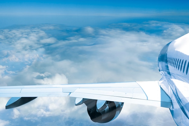 Passenger jet plane flies above the clouds