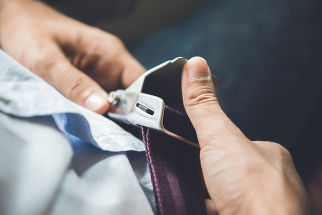 Passenger releasing seat belt while sitting on the airplane preparing to get off