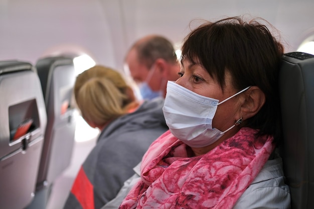 Passenger woman in medical mask in plane