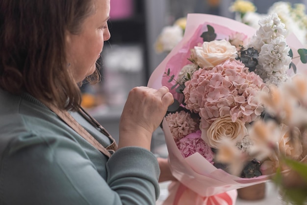 Passion for flowers and design expert female florist and business owner creates a stunning bouquet