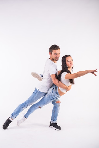 Passionate couple dancing social danse kizomba or bachata or semba or taraxia on white wall