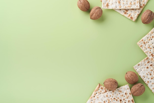 Passover celebration concept Matzah red kosher and walnut Traditional ritual Jewish bread on light green monochrome background Spring Passover food Pesach Jewish holiday