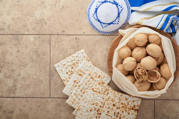 Passover celebration concept Matzah red kosher and walnut Traditional ritual Jewish bread matzah kippah and tallit on old concrete background Passover food Pesach Jewish holiday