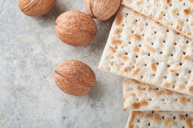 Passover celebration concept Matzah red kosher and walnut Traditional ritual Jewish bread matzah kippah and tallit on old concrete background Passover food Pesach Jewish holiday