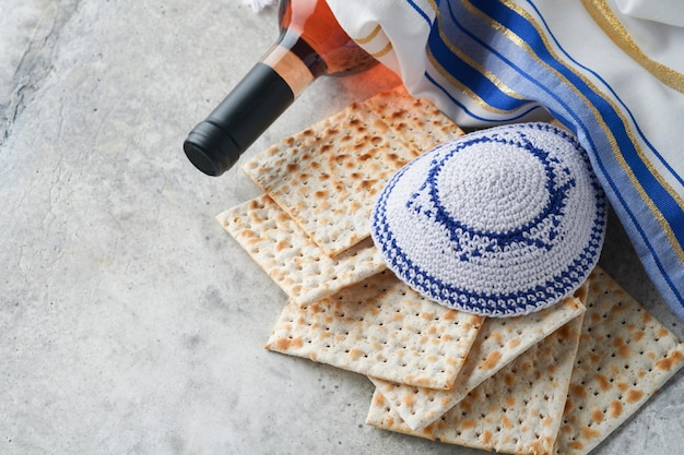 Passover celebration concept Matzah red kosher and walnut Traditional ritual Jewish bread matzah kippah and tallit on old concrete background Passover food Pesach Jewish holiday