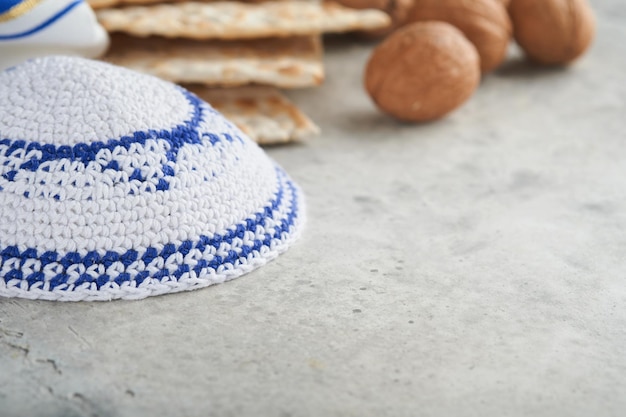 Passover celebration concept Matzah red kosher and walnut Traditional ritual Jewish bread matzah kippah and tallit on old concrete background Passover food Pesach Jewish holiday