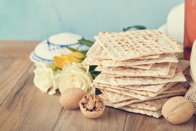 Passover celebration concept Matzah red kosher and walnut Traditional ritual Jewish bread matzah kippah and tallit on old wooden background Passover food Pesach Jewish holiday Toned image