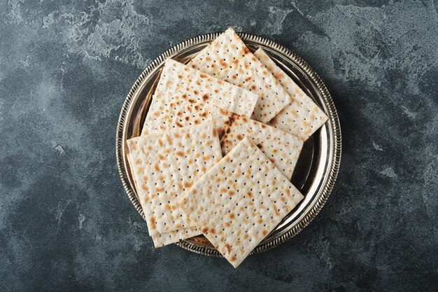 Passover celebration concept Matzah red kosher and walnut Traditional ritual Jewish bread on old dark grey concrete background Passover food Pesach Jewish holiday