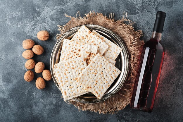 Passover celebration concept Matzah red kosher and walnut Traditional ritual Jewish bread on old dark grey concrete background Passover food Pesach Jewish holiday