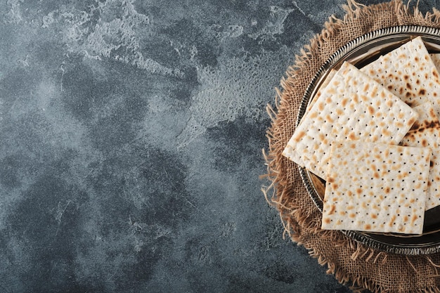 Passover celebration concept Matzah red kosher and walnut Traditional ritual Jewish bread on old dark grey concrete background Passover food Pesach Jewish holiday