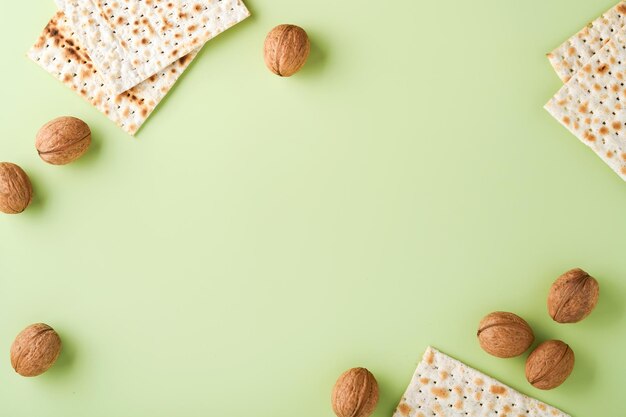 Passover celebration concept Matzah red kosher wine and walnut Traditional ritual Jewish bread on light green background Passover food Pesach Jewish holiday