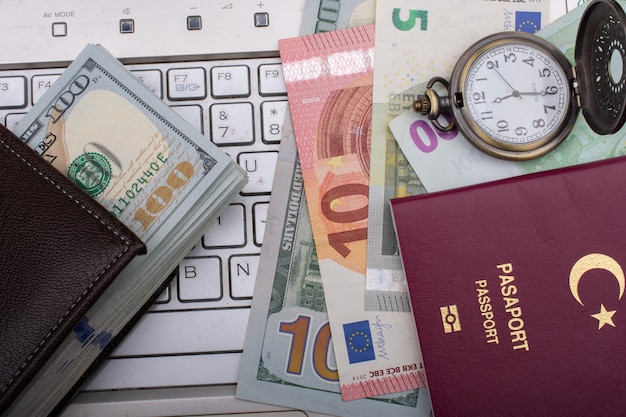 Passport of a citizen of the Turkey beside Euro banknotes keyboard and pocket watch