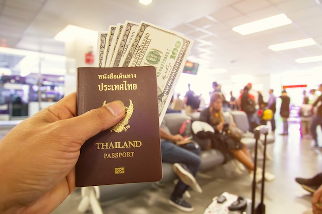 Passport and dollar in male hands sitting in the airport