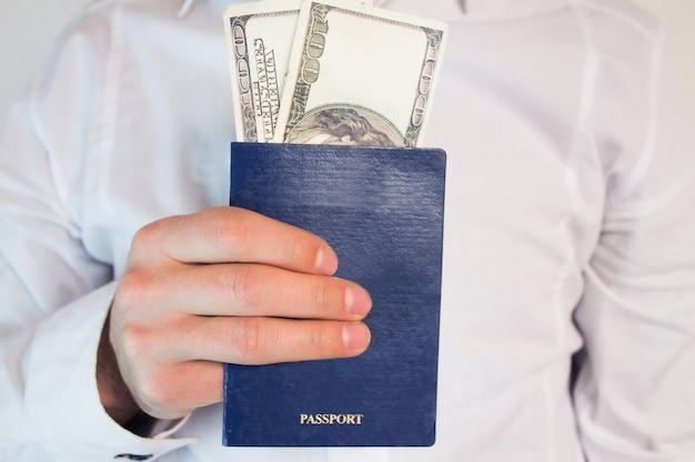 Passport and dollars with businessman hand