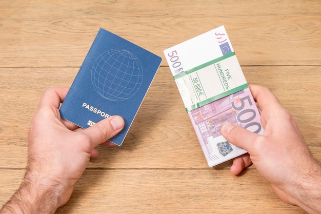 passport and euro money in male hands on the background of an old wooden table