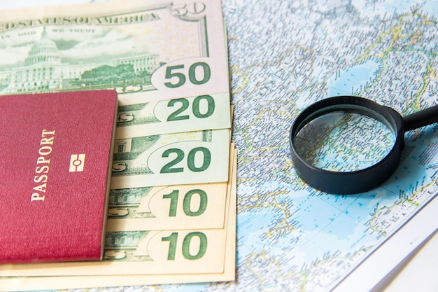 Passport magnifier and money on map Travel budget planning concept