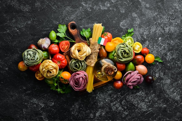 Pasta background dry pasta tagliatelle and ingredients on black background Top view Free space for your text