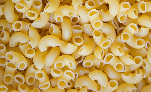 Pasta background raw macaroni texture background close up raw macaroni pasta uncooked delicious pasta for cooking food