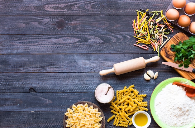 Pasta background. Several types of pasta with vegetables,  Free space for text. Top view