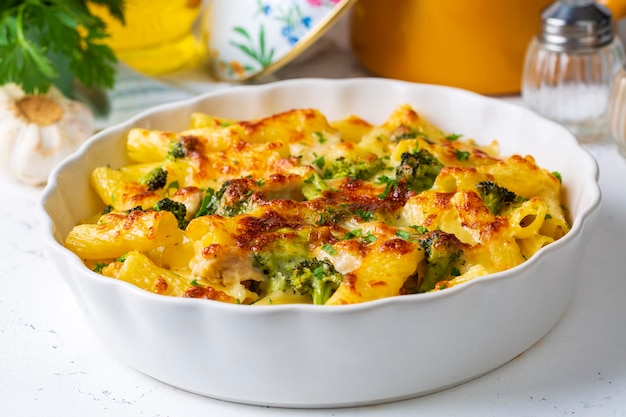 Pasta baked with broccoli and chicken. Broccoli, cheese and gratin sauce on baked penne pasta.