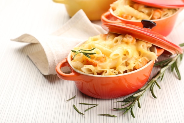 Pasta baked with shrimps and cheese in ceramic pot