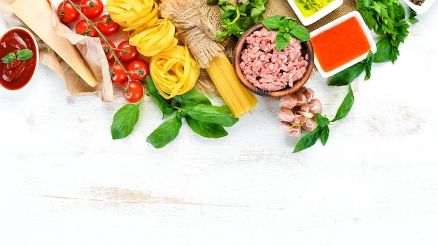 Pasta Bolognese and Ingredients On a white wooden background Top view Free space for your text