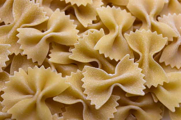 Pasta bows from durum wheat Food background close up Uncooked Italian pasta