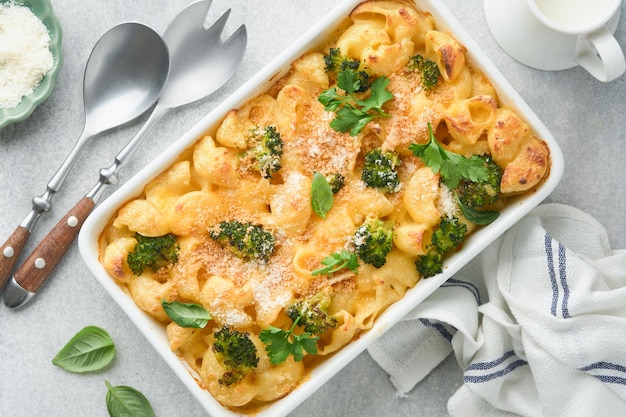 Pasta Broccoli casserole Baked Mac and cheese with broccoli cream sauce and parmesan on gray light concrete table background Healthy or baby food American Casserole Top view Copy space