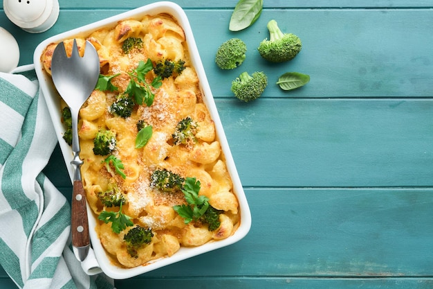 Pasta Broccoli casserole Baked Mac and cheese with broccoli cream sauce and parmesan on old rustic wooden background Healthy or baby food American Casserole Top view Copy space